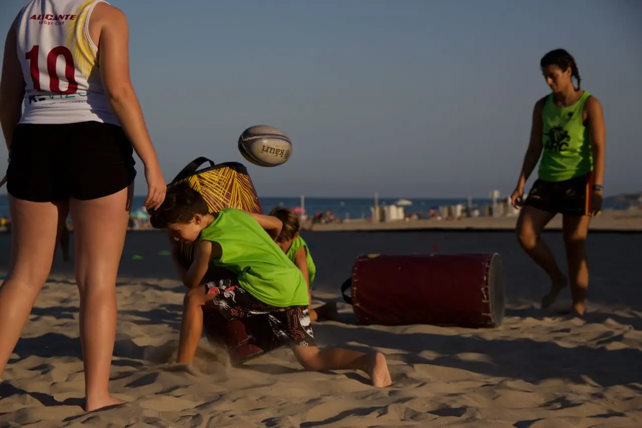 Chavales entrenando rugby en la Playa de San Juan durante el Campus de Rugby Playa